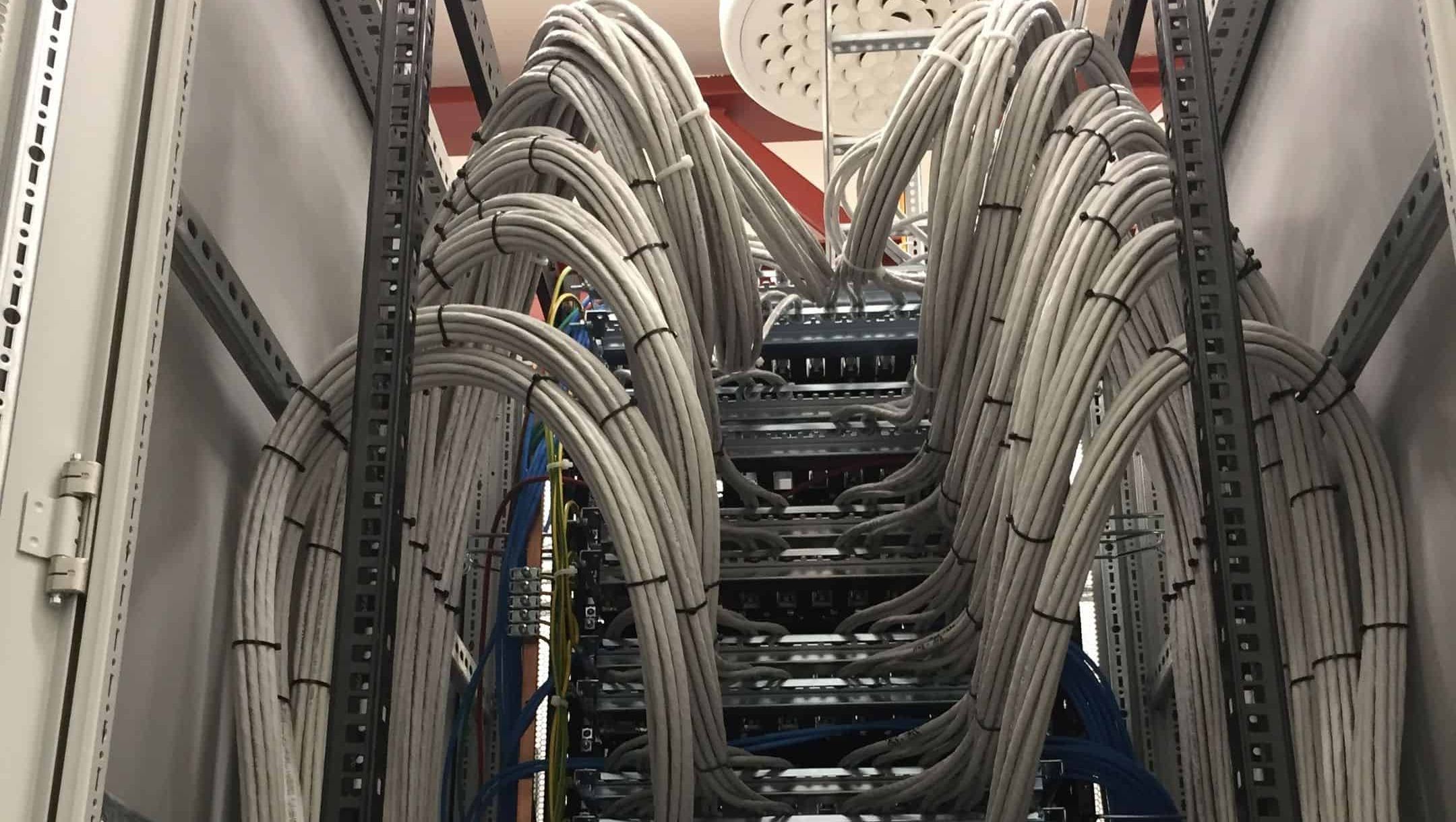 Kabelsystem i serverrom med tykke nettverkskabler bundet sammen.